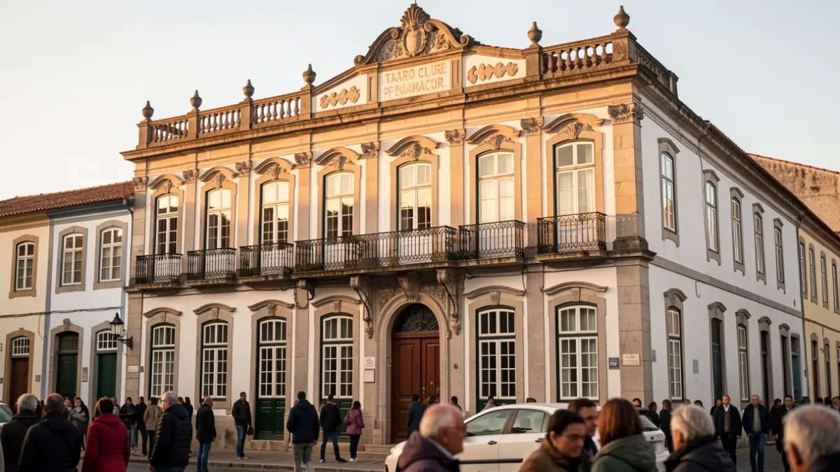 Facade of the Teatro Clube de Penamacor, a traditional Portuguese building with ornate details, bathed in the warm light of late afternoon.