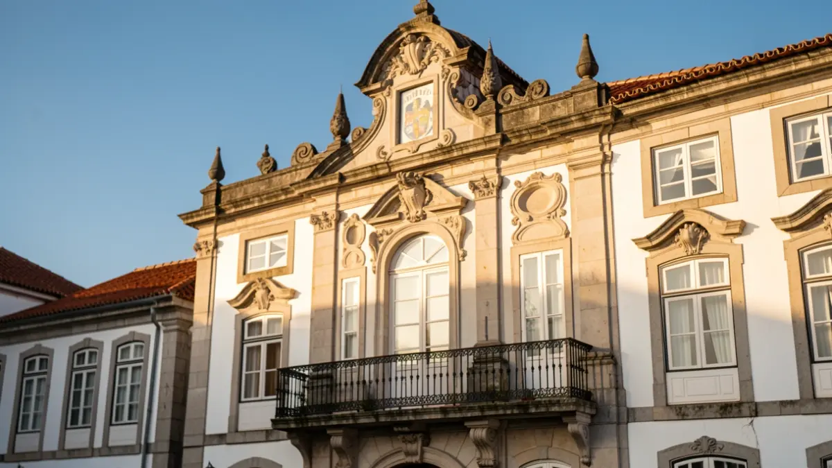 Imagem genérica de uma fachada de edifício municipal em Portugal, com detalhes arquitetónicos tradicionais e luz solar.