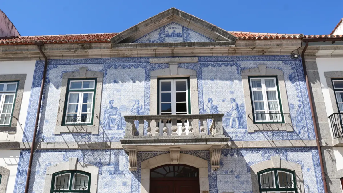 Imagem genérica de uma Câmara Municipal portuguesa com azulejos tradicionais e varanda de pedra, sob um céu azul claro.