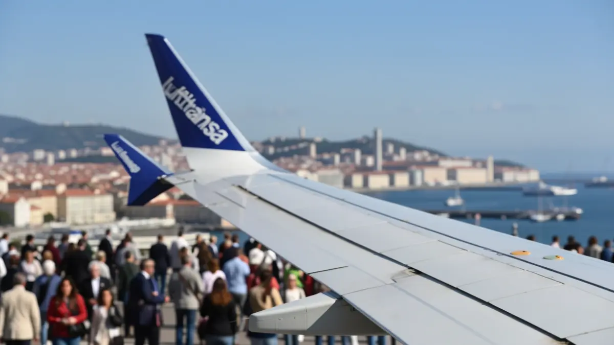 Generic image of a Lufthansa airplane wing with the Portuguese coast and Lisbon in the background.