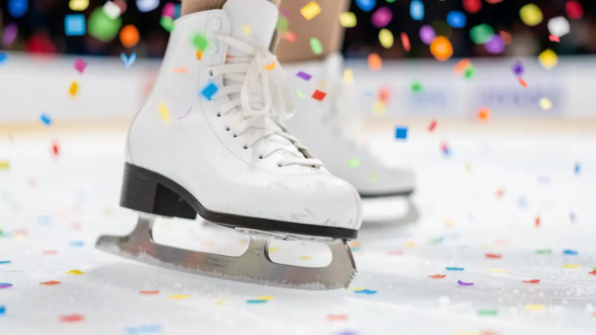 Generic image of an artistic ice skating blade on ice, with blurred colorful confetti in the background.