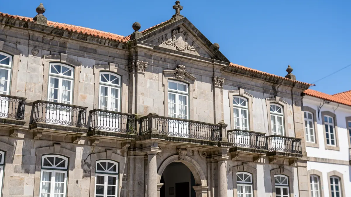 Fachada da Câmara Municipal de Ponta Delgada, um edifício histórico com arquitetura portuguesa sob um céu azul.