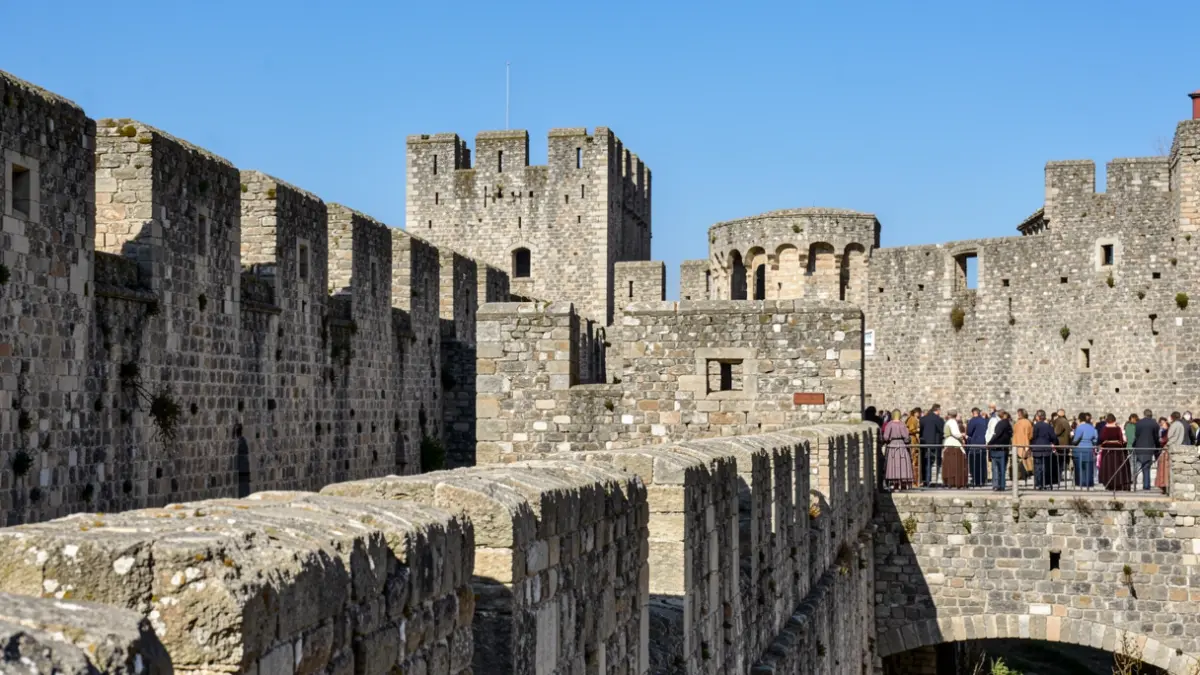 Imagen genérica de murallas y baluartes de piedra de una fortaleza europea antigua, con el cielo azul al fondo.